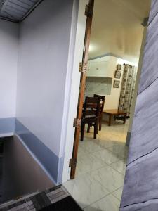 a door leading into a kitchen with a table and chairs at Teachers Home in Panong