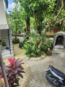 a garden with a motorcycle parked next to a bench at Teachers Home in Panong