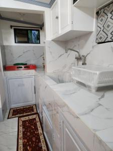 a kitchen with white marble counters and a sink at Teachers Home in Panong