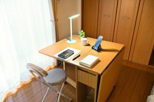 a wooden desk with a laptop computer on it at 民泊 Ichinomiya K Room 1A in Ichinomiya