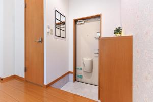 a bathroom with a door and a toilet in a room at 民泊 Ichinomiya K Room 1A in Ichinomiya +14 photos