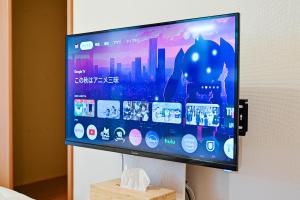 a flat screen tv hanging on a wall at 民泊 Ichinomiya K Room 1A in Ichinomiya