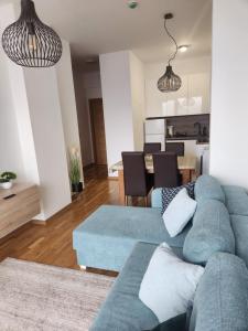 a living room with a blue couch and a dining room at Mountain View -ski & mountain retreat, Apartment 01 PRIZEMLJE u Premium objektu in Jahorina