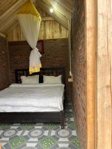 a bedroom with a bed in a brick wall at Chi Homestay in Sapa +2 photos