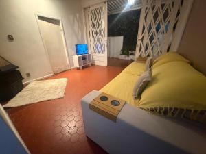 une chambre avec un lit et une télévision dans l'établissement Casa Paraíso Verde, à Petrópolis