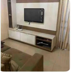 a living room with a flat screen tv on the wall at Rua 220 in Itapema