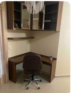 a computer desk with a chair in a room at Rua 220 in Itapema