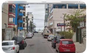 a city street with cars parked on the street at Rua 220 in Itapema