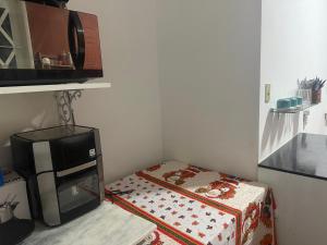 une petite cuisine avec un micro-ondes et une cuisinière dans l'établissement Casa Paraíso Verde, à Petrópolis