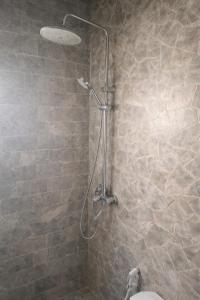 a shower in a bathroom with a stone wall at Villa Kaba Hippodrome Électricité solaire 24h24 in Bamako +25 photos