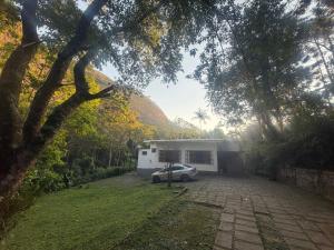 une voiture garée devant un garage dans l'établissement Casa Paraíso Verde, à Petrópolis