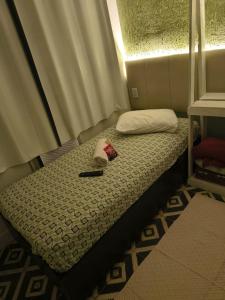 een klein bed met een hoed en een pen erop bij Casa espaçosa para 8 hóspedes in Volta Redonda +6 foto's