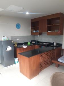 eine Küche mit schwarzer Theke und Kühlschrank in der Unterkunft C-VIEW BOUTIQUE in Rawai Beach + 19 Fotos
