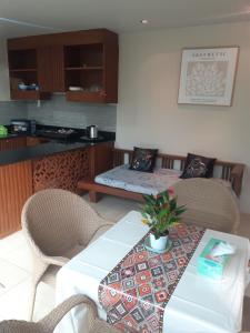 ein Wohnzimmer mit Tisch und Stühlen und eine Küche in der Unterkunft C-VIEW BOUTIQUE in Rawai Beach