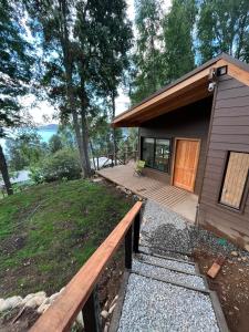una piccola casa con un portico in legno e un ponte di Cabaña Los Arrayanes 2 a Coihueco