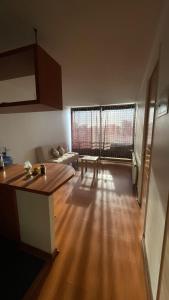 un soggiorno con divano e pavimento in legno di Departamento tauro a Santiago