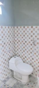 ein Badezimmer mit Toilette und gefliester Wand in der Unterkunft Rumah singgah view city light in Baturaden
