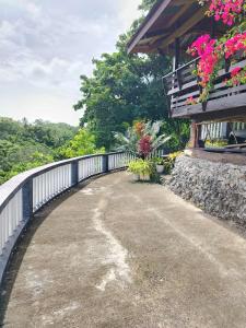 a walkway next to a building with flowers on it at Hilltop Cottage in Cabulihan