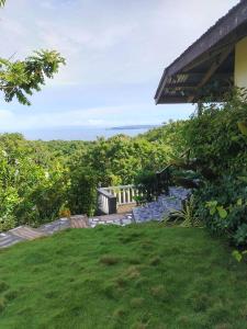 a yard with a view of the ocean from a house at Hilltop Cottage in Cabulihan