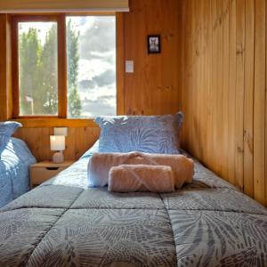 a bedroom with a bed with a pillow and a window at Cabaña 1 - Rancho Doble AA in La Junta