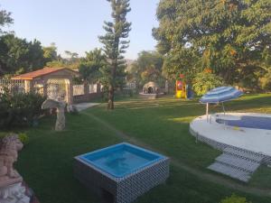 een achtertuin met een zwembad en een parasol bij La Victoria Resort & Spa  +1 foto