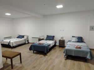 a bedroom with two beds and a table and a chair at Alvarez Apart in Ushuaia