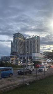 a large building with cars parked in a parking lot at Mikayla Suite in Kota Bharu