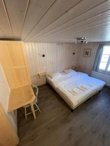 a small room with a bed and a chair at L'Auberge de la Combal in La Comballaz