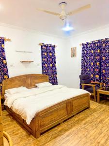 een slaapkamer met een houten bed en blauwe gordijnen bij Greenoriva Aero Srinagar in Srinagar