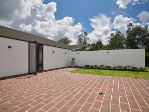 a house with white walls and a brick courtyard at Casa Guasca in Guasca