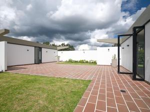 une cour avec une allée en briques devant un bâtiment blanc dans l'établissement Casa Guasca, à Guasca 8 autres photos