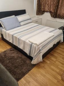 ein Bett mit einer blauen und weißen Decke und einem Teppich in der Unterkunft Relax in this Charming Rushden Retreat in Rushden