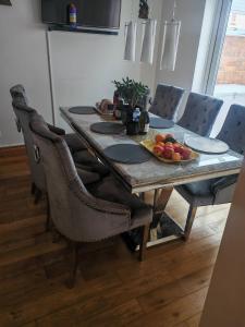einen Esstisch mit einer Obstschale darauf in der Unterkunft Relax in this Charming Rushden Retreat in Rushden
