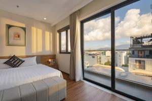 a bedroom with a bed and a large window at Grand Lux by BRIO in Danang