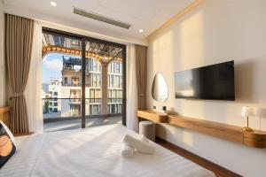 a hotel room with a large window and a tv at Grand Lux by BRIO in Danang