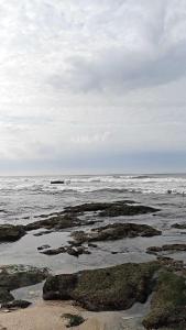 een strand met rotsen en de oceaan op een bewolkte dag bij huazhi in Accra