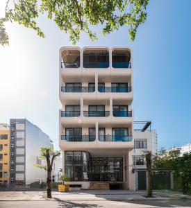 a tall white building with a lot of windows at Grand Lux by BRIO in Danang