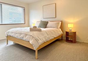 una camera da letto con un letto grande con due lampade di Relaxed Mount Getaway Close to Beach & Town a Mount Maunganui