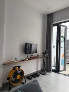 a living room with a desk with a television and a fan at Town House for rent in Thủ Đức in Ho Chi Minh City