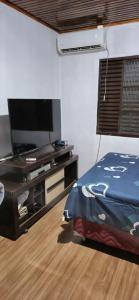 a bedroom with a bed and a flat screen tv at Casa do Fernando in São Gabriel +6 photos
