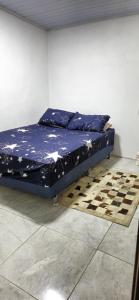 a bed in a room with a chess board on the floor at Casa do Fernando in São Gabriel