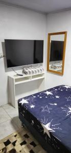 a bedroom with a bed and a mirror and a tv at Casa do Fernando in São Gabriel