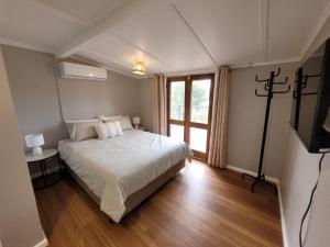 ein Schlafzimmer mit einem weißen Bett und einem Fenster in der Unterkunft Tweed River Waterfront Cottage in Murwillumbah