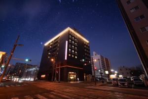a tall building with lights on top of it at night at HOTEL THE7 Kumamoto in Kumamoto +122 photos