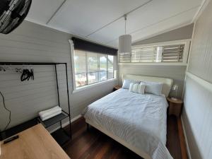 ein kleines Schlafzimmer mit einem Bett und einem Fenster in der Unterkunft Tweed River Waterfront Cottage in Murwillumbah