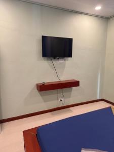 une pièce avec une télévision à écran plat sur un mur dans l'établissement Little Hill, à Haad Rin