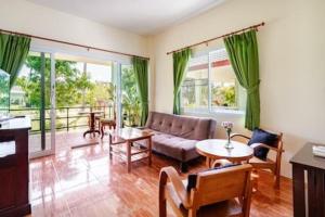 a living room with a couch and a table at Green Heaven Bungalows in Ban Bang Po +5 photos