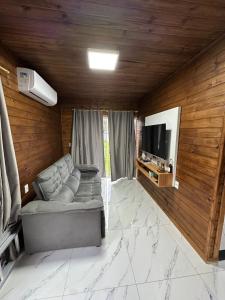 een woonkamer met een bank en een flatscreen-tv bij Casa Aconchego in Florianópolis +12 foto's