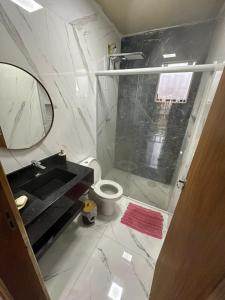een badkamer met een wastafel, een toilet en een spiegel bij Casa Aconchego in Florianópolis