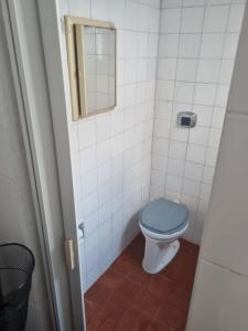 een badkamer met een blauw toilet en een spiegel bij Casa da Bisa Ubatuba in Ubatuba +10 foto's